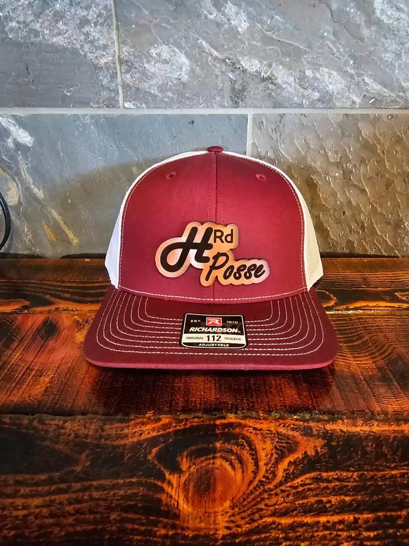 Red and white trucker hat with a script leather patch