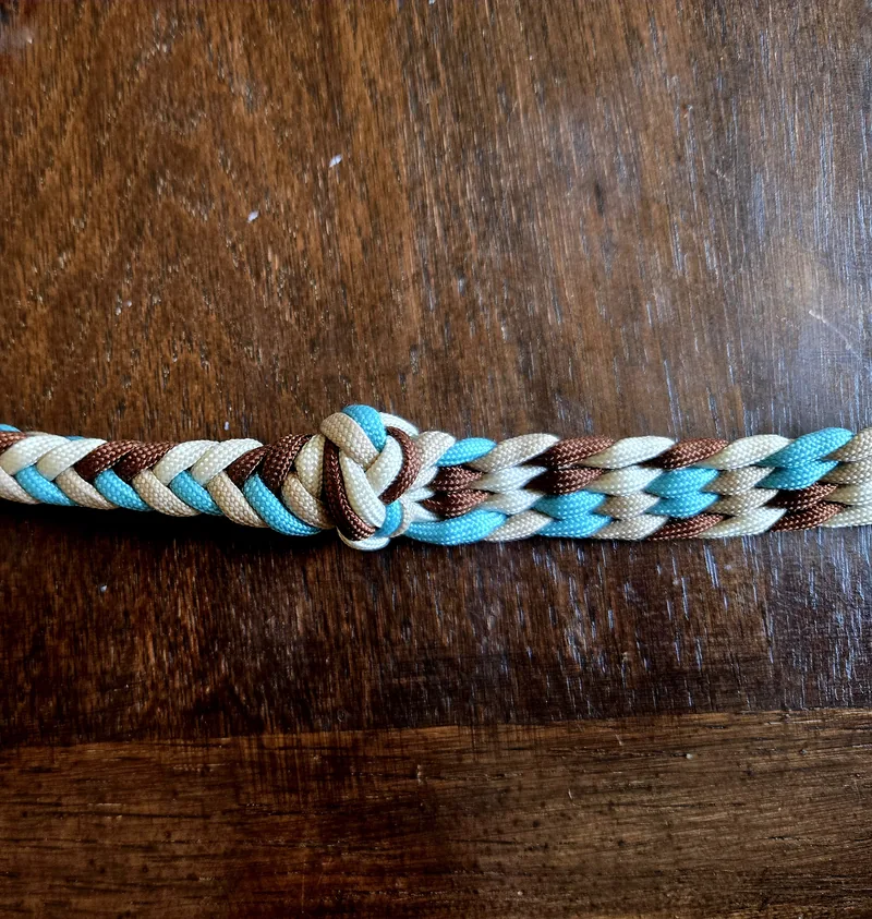 Close-up of a grip knot in a Desert Turquoise braid: turquoise, tan, cream and chocolate