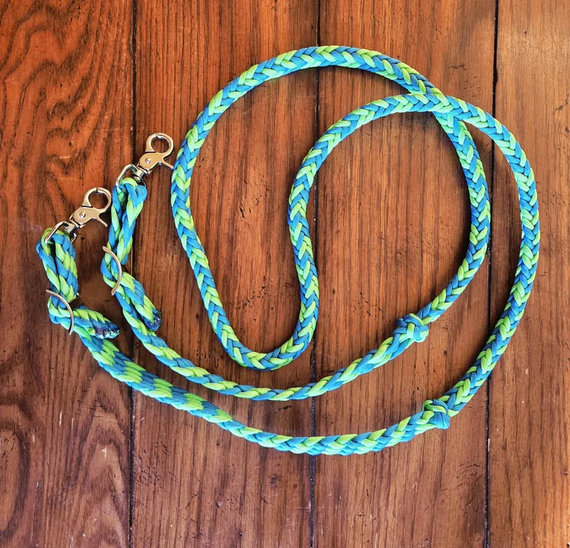 Turquoise and lime braided reins with brass snaps, on wood